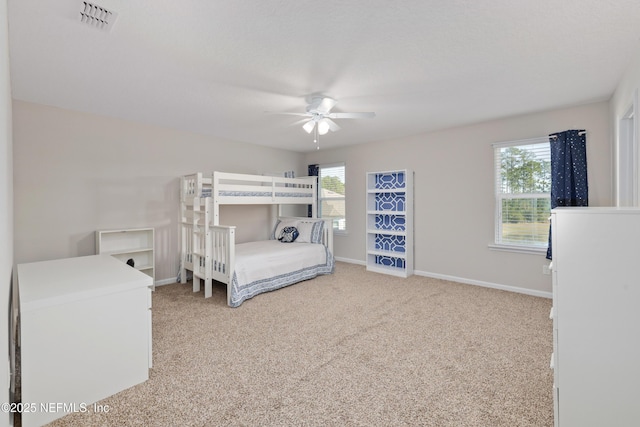 unfurnished bedroom with multiple windows, carpet floors, and ceiling fan