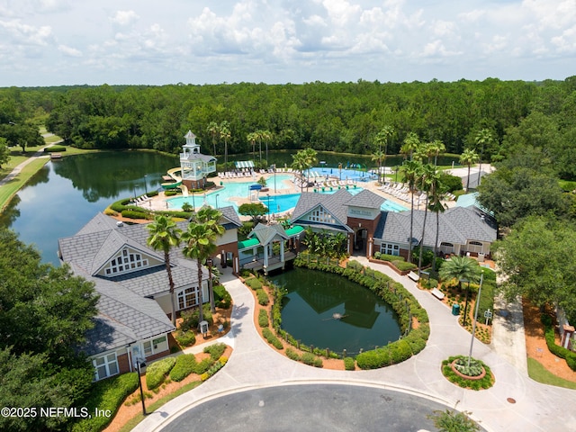 birds eye view of property featuring a water view and a wooded view