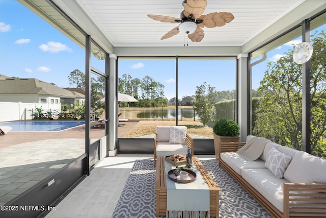 sunroom featuring a ceiling fan, a water view, and plenty of natural light