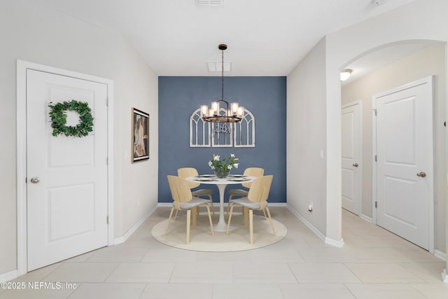 dining room with visible vents, arched walkways, a chandelier, and baseboards