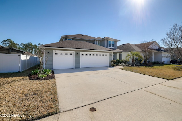 traditional-style home with concrete driveway, a front lawn, an attached garage, and fence