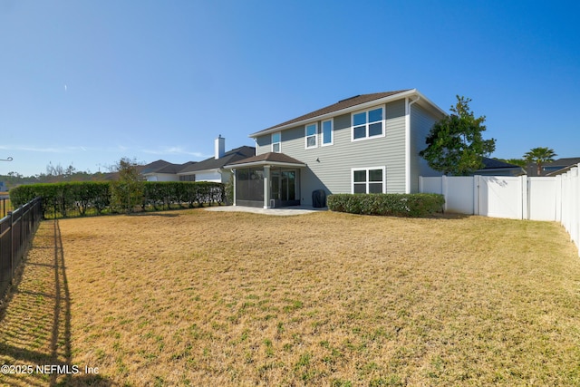 back of property featuring a yard, a patio, a chimney, and a fenced backyard