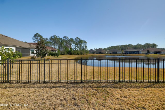 view of yard featuring a water view and fence