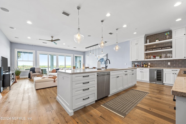 kitchen featuring white cabinetry, dishwasher, beverage cooler, and decorative light fixtures