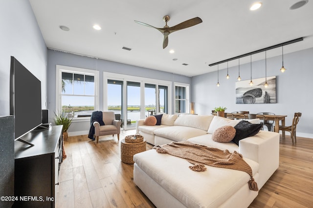 living room with ceiling fan and light wood-type flooring