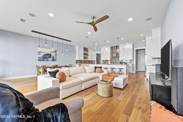 living room featuring light hardwood / wood-style floors and ceiling fan