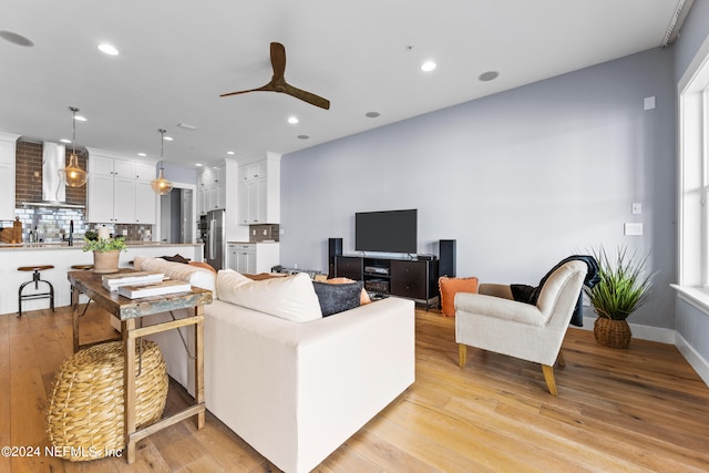 living room featuring ceiling fan and light hardwood / wood-style flooring