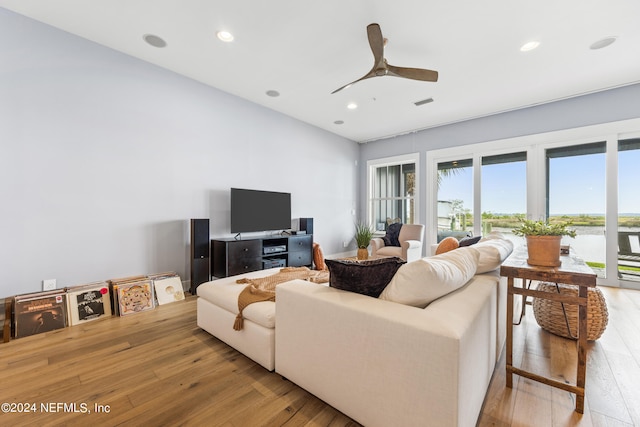 living room featuring ceiling fan and light hardwood / wood-style floors