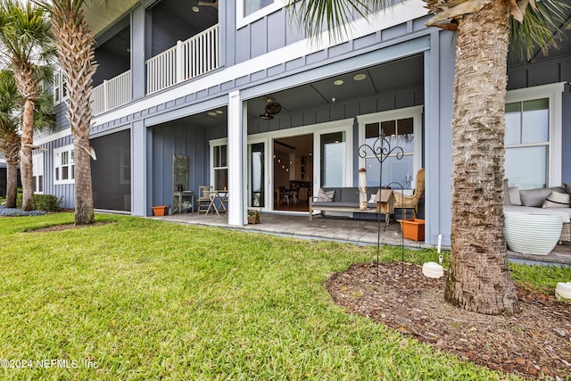 view of exterior entry with a yard and a patio