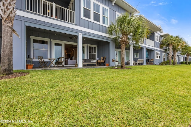 rear view of property featuring a lawn and a balcony