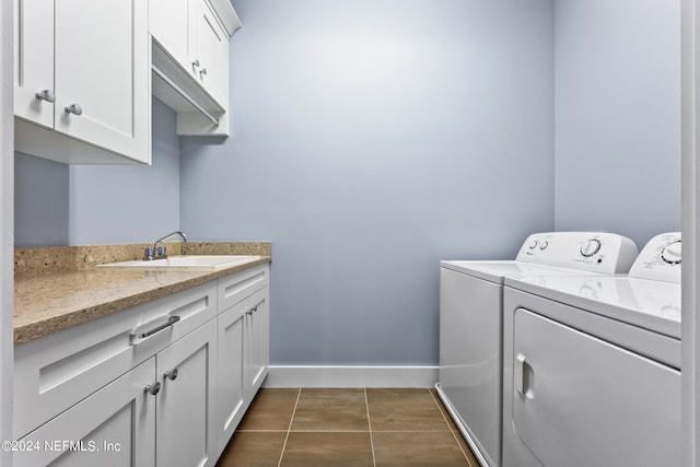 laundry area with cabinets, sink, washing machine and clothes dryer, and dark tile patterned flooring