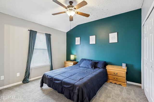 carpeted bedroom featuring lofted ceiling, a textured ceiling, ceiling fan, and a closet