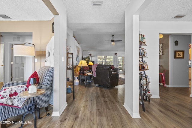 foyer entrance with hardwood / wood-style flooring, a textured ceiling, and ceiling fan