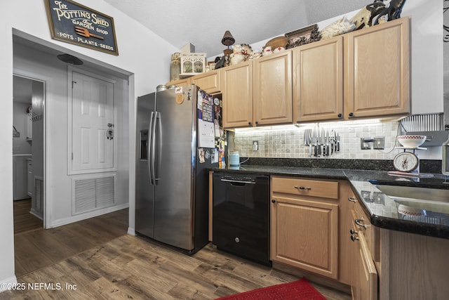 kitchen featuring dishwasher, stainless steel refrigerator with ice dispenser, dark hardwood / wood-style flooring, decorative backsplash, and vaulted ceiling