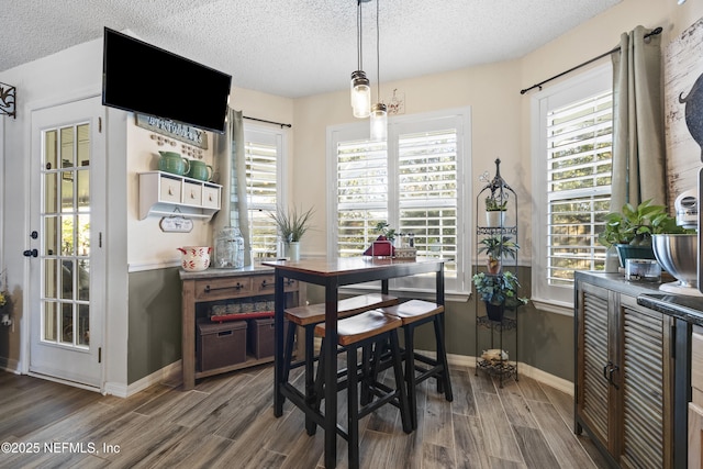 dining space featuring dark hardwood / wood-style flooring and a textured ceiling