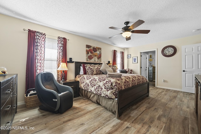 bedroom with ceiling fan, hardwood / wood-style floors, and a textured ceiling