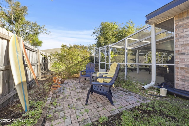 view of patio featuring a lanai