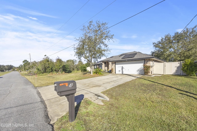 view of front of house featuring a garage, a front yard, and solar panels