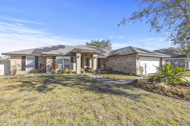 view of front of property featuring a garage, a front yard, and solar panels