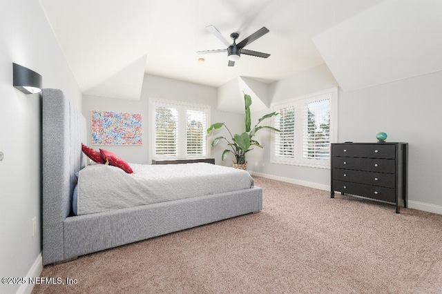 bedroom featuring carpet floors, lofted ceiling, multiple windows, and baseboards