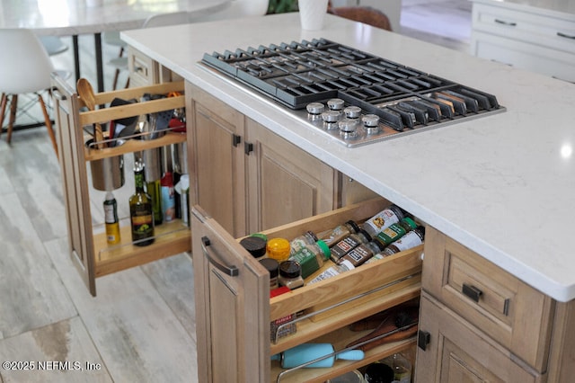 kitchen featuring open shelves, light wood-style floors, stainless steel gas cooktop, and light countertops