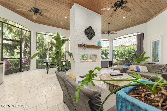 sunroom with lofted ceiling, wooden ceiling, and an outdoor stone fireplace