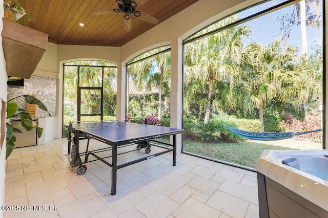 unfurnished sunroom featuring ceiling fan and wood ceiling