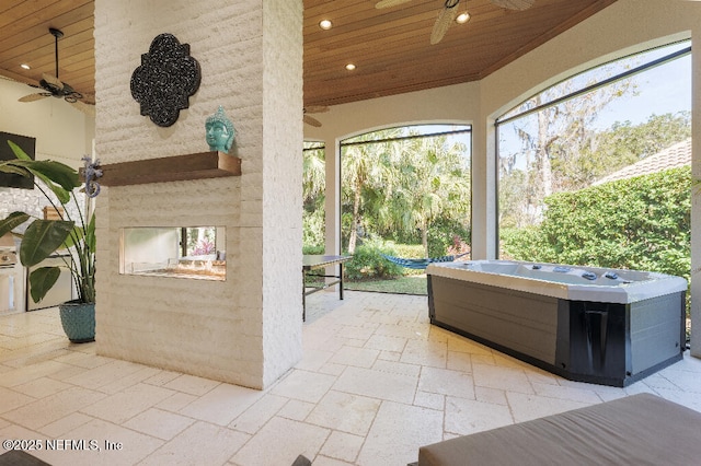 view of patio / terrace with exterior fireplace and a ceiling fan