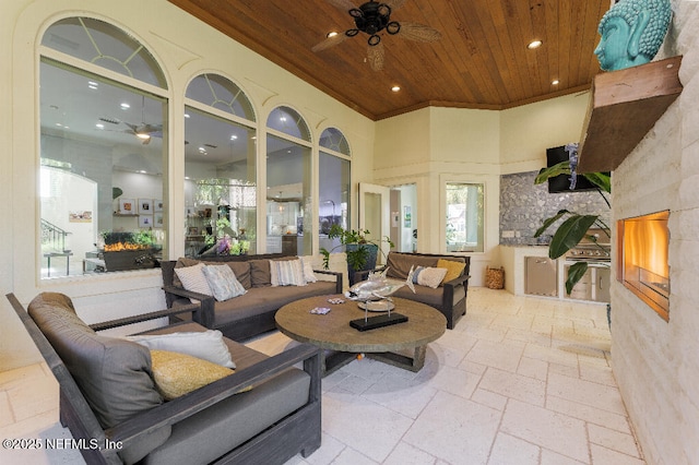 living area featuring stone tile flooring, wood ceiling, ceiling fan, and recessed lighting