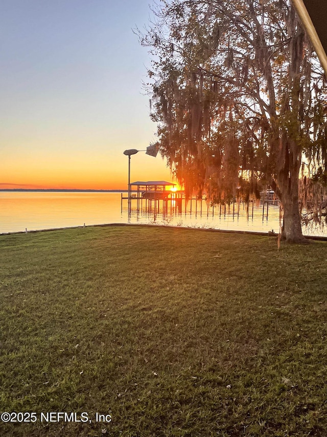 view of property's community featuring a water view and a yard