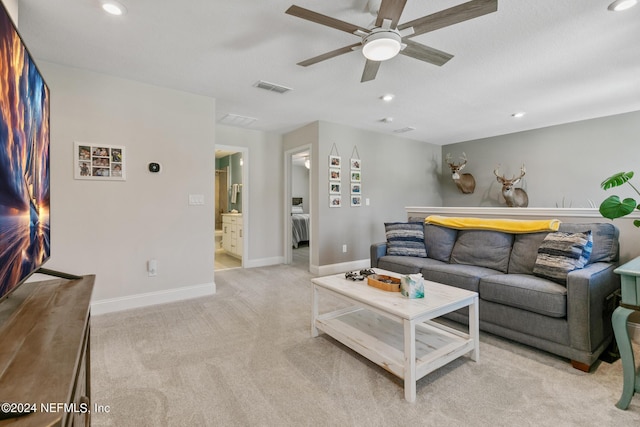 living room with ceiling fan and light colored carpet