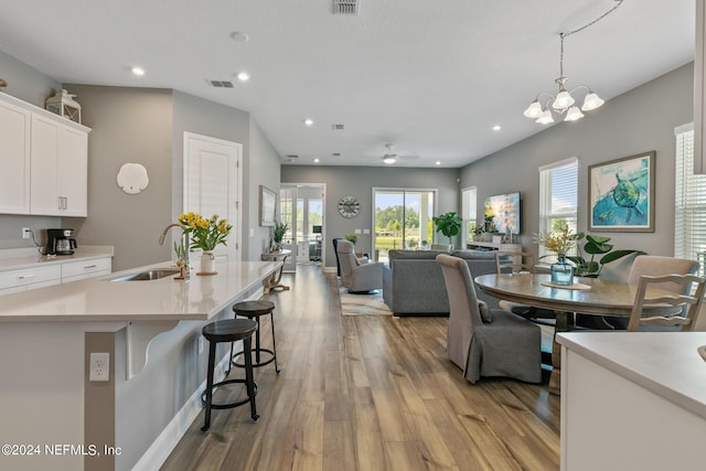 interior space featuring a notable chandelier, sink, and light wood-type flooring