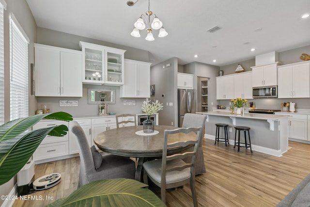 dining area featuring an inviting chandelier and light hardwood / wood-style flooring