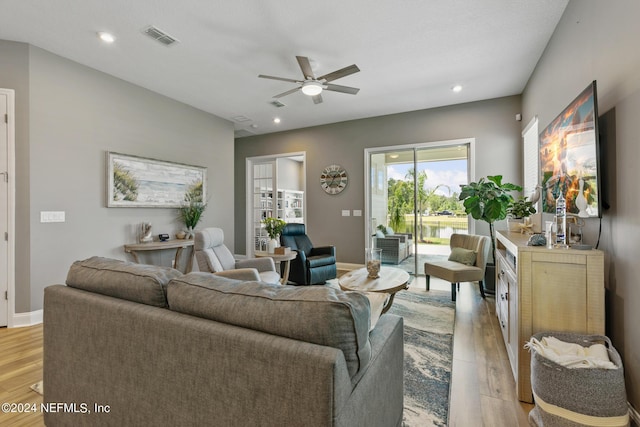 living room featuring ceiling fan and light wood-type flooring