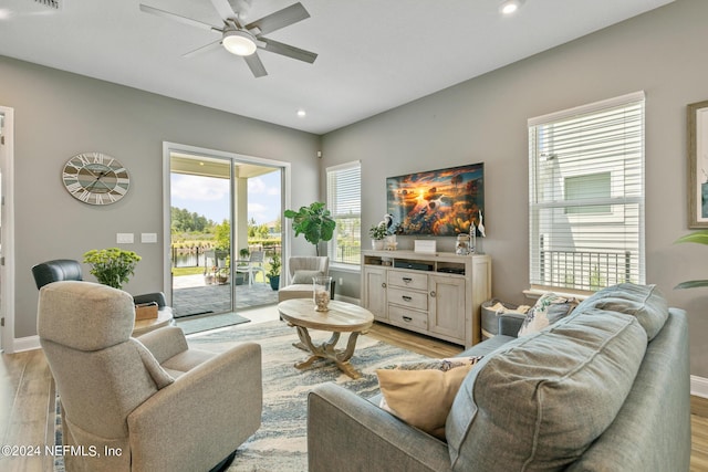 living room with ceiling fan and light hardwood / wood-style flooring