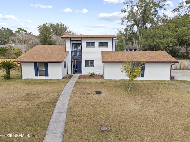 view of front of property featuring a balcony and a front lawn