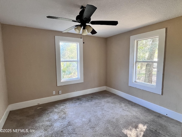 carpeted spare room featuring ceiling fan and a textured ceiling