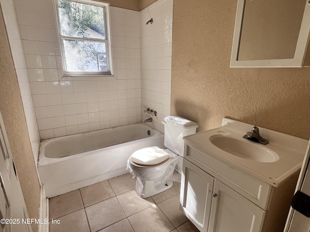 full bathroom with vanity, tiled shower / bath, tile patterned floors, and toilet