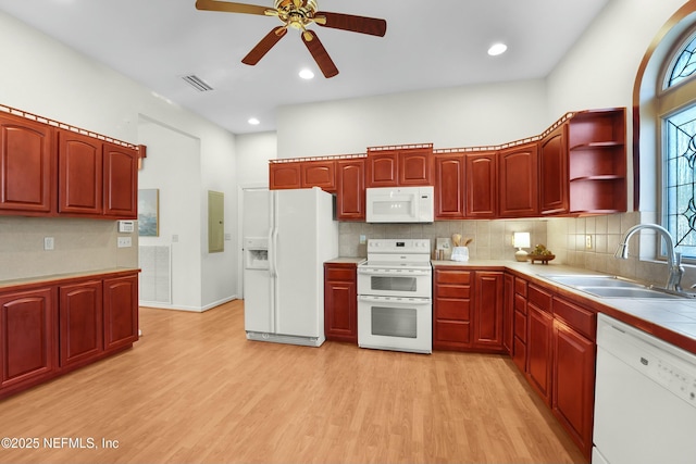 kitchen featuring white appliances, sink, light hardwood / wood-style flooring, and backsplash