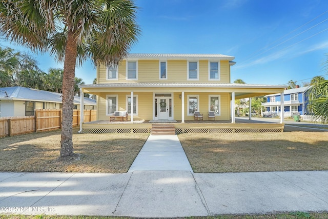 farmhouse with covered porch and a front yard