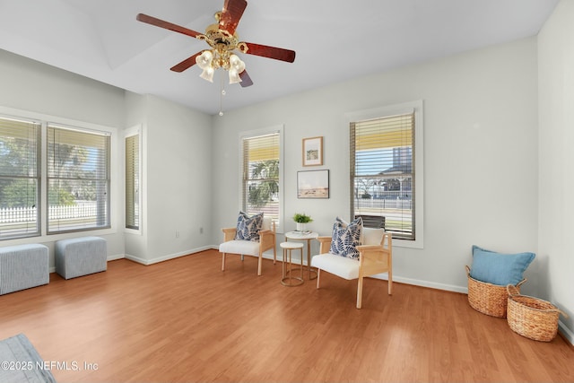 living area with light hardwood / wood-style floors and ceiling fan