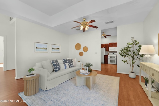 living room featuring ceiling fan and light hardwood / wood-style flooring