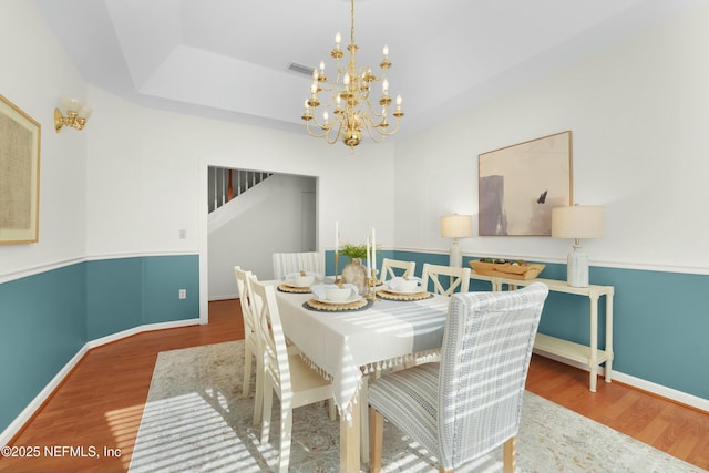 dining room with an inviting chandelier and wood-type flooring