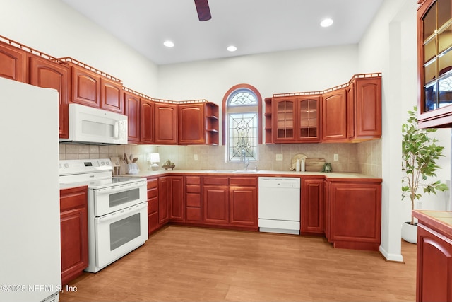 kitchen featuring tasteful backsplash, white appliances, sink, and light hardwood / wood-style flooring