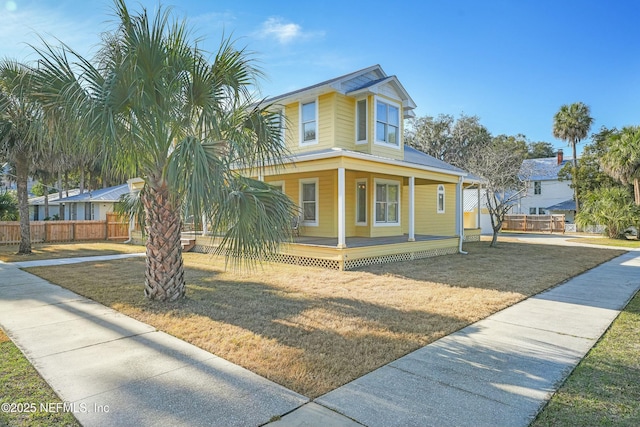 country-style home with a front yard and covered porch