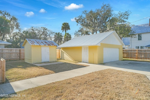 view of front of property with a garage, a front yard, and a storage unit