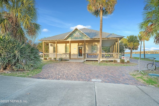 view of front facade featuring a water view and a porch