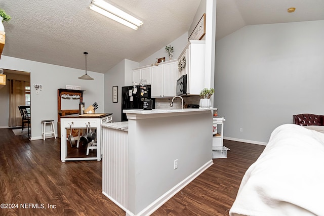 kitchen with white cabinetry, pendant lighting, vaulted ceiling, and black appliances