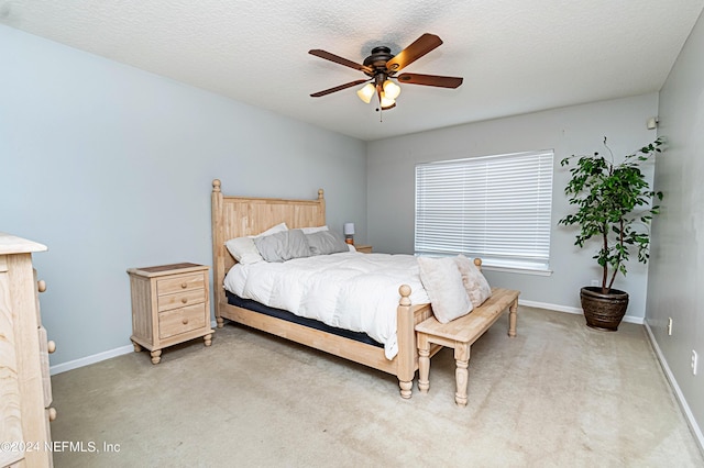 carpeted bedroom with a textured ceiling and ceiling fan