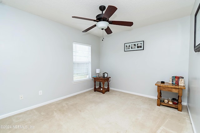 carpeted spare room with ceiling fan and a textured ceiling